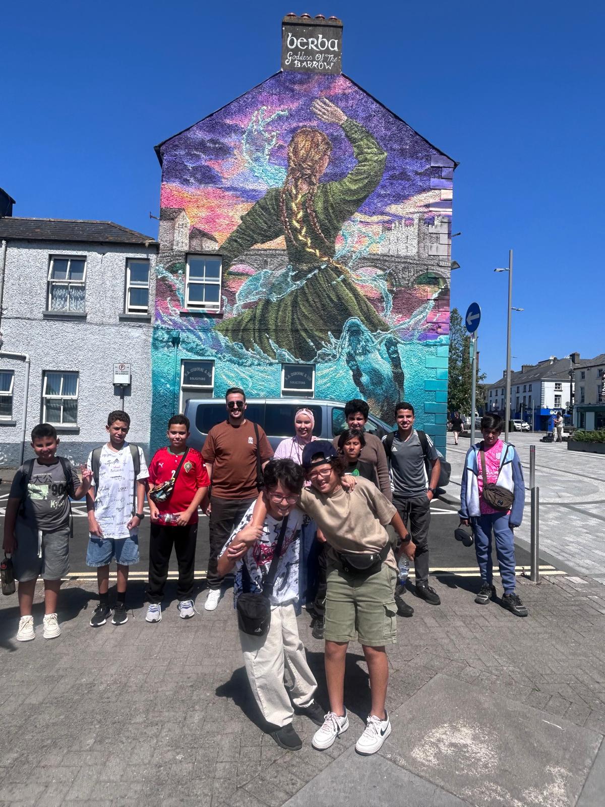 Student group gathered by a colourful street-art mural
